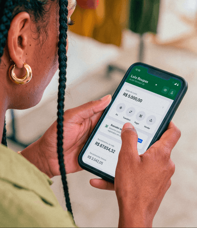 Mão segurando o celular com o app Stone aberto na tela de saldo da Lolo Roupas