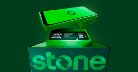 Maquininha Stone saindo de uma caixa da marca com logotipo Stone iluminado em verde