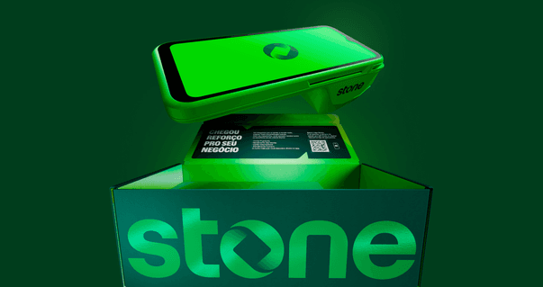Maquininha Stone saindo de uma caixa da marca com logotipo Stone iluminado em verde