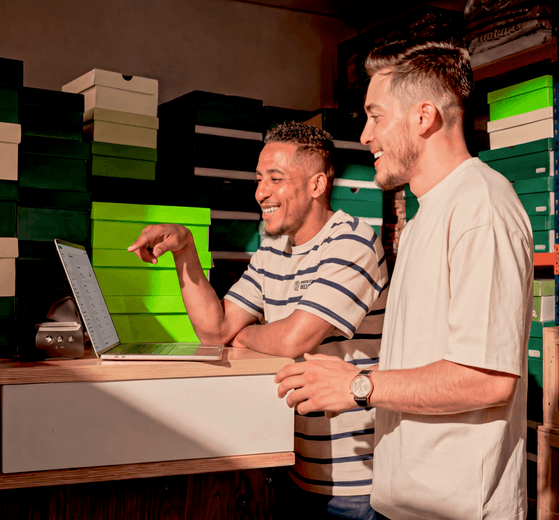 homens sorrindo e mexendo no computador