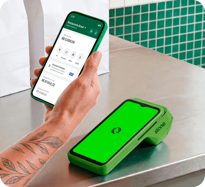 Atendente em restaurante segurando o celular com app Stone aberto ao lado da maquininha Stone com logo na tela