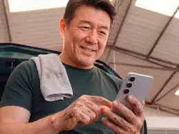 Mecânico em oficina usando um celular