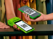 Cliente em loja de roupa pagando via qrcode na maquininha