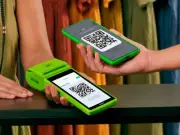 Cliente em loja de roupa pagando via qrcode na maquininha