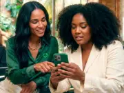 Duas mulheres visualizando algo em um celular no salão de beleza