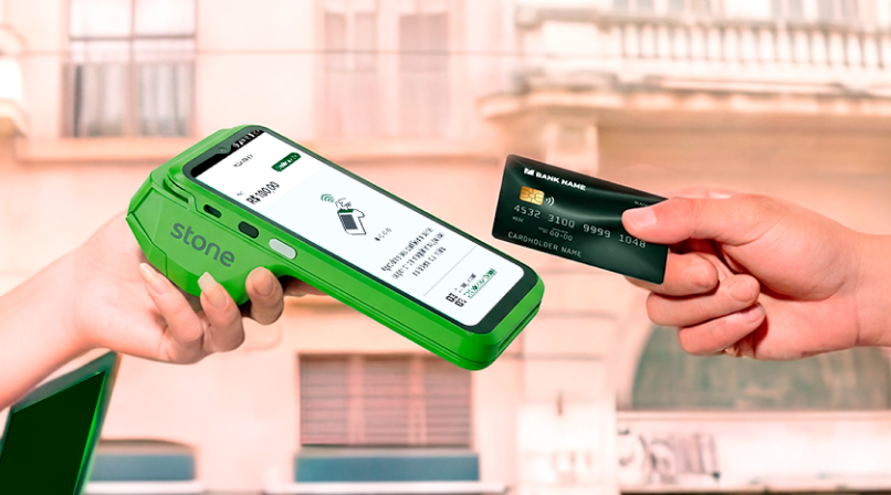 Cliente pagando com cartão em maquininha Stone verde com QR Code na tela