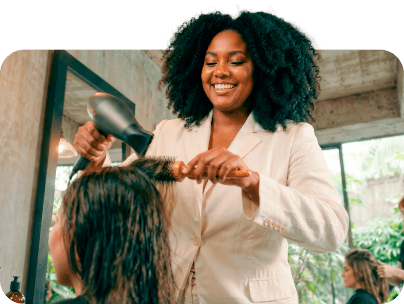 Mulher em um salão escovando o cabelo de uma cliente