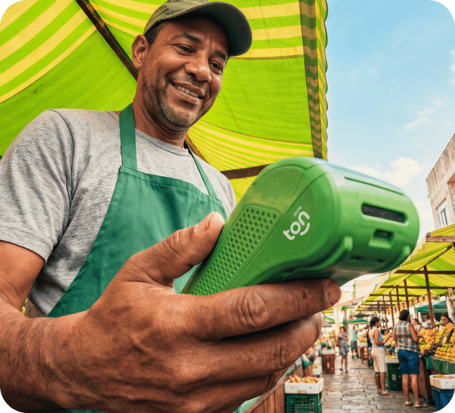 Homem feirante sorrindo e mexendo no celular