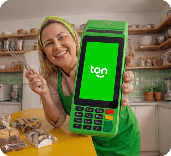 Mulher cozinheira sorrindo e segurando a a maquininha Ton