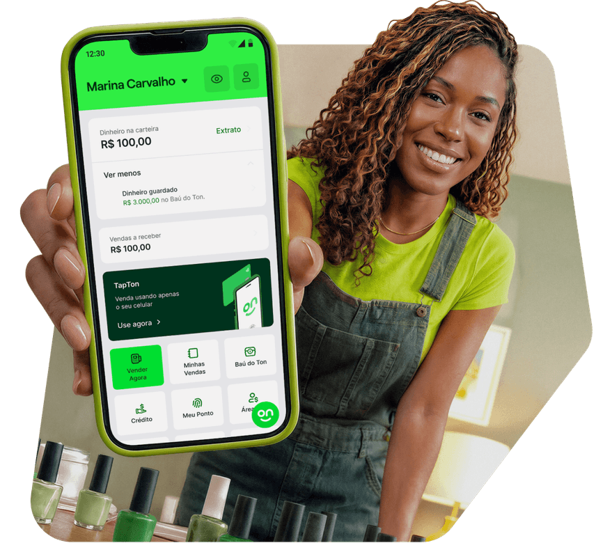 Empreendedora manicure sorrindo mostrando o app Ton no celular em seu salão