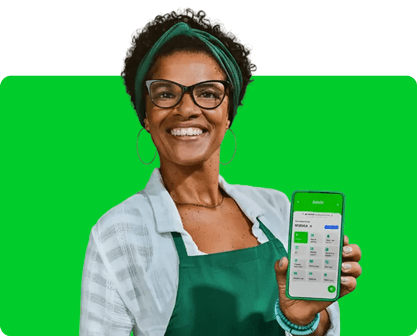 Empreendedora segurando o celular com o app Ton em seu estabelecimento