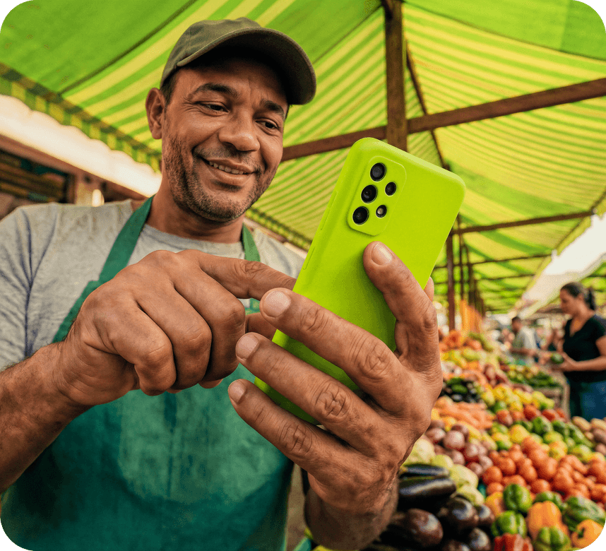 Homem sorrindo com o celular na mão