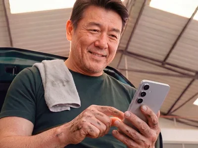 Mecânico em oficina usando um celular