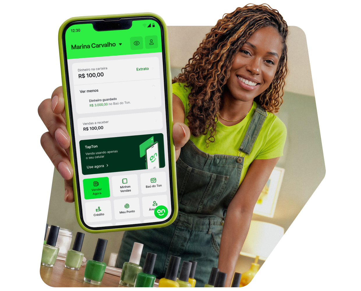 Mulher sorrindo, vestindo avental de trabalho e mostrando a tela do celular com o aplicativo do Ton