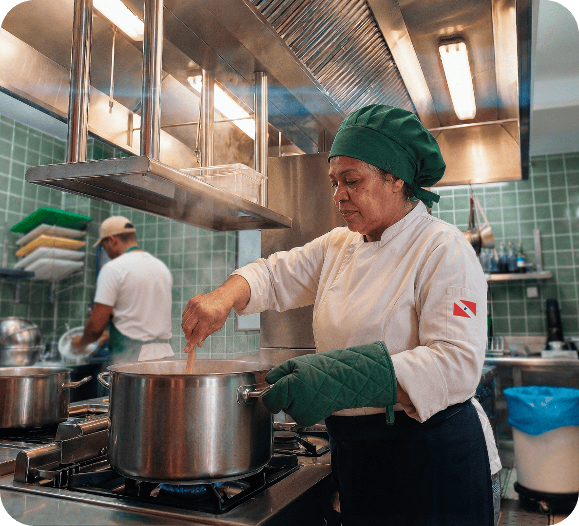 Chef em cozinha de restaurante mexendo uma panela no fogão