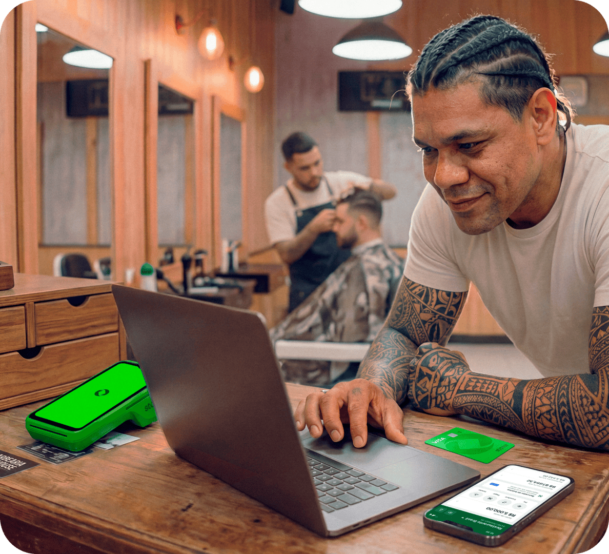Funcionário em barbearia utilizando um computador junto com a maquininha stone
