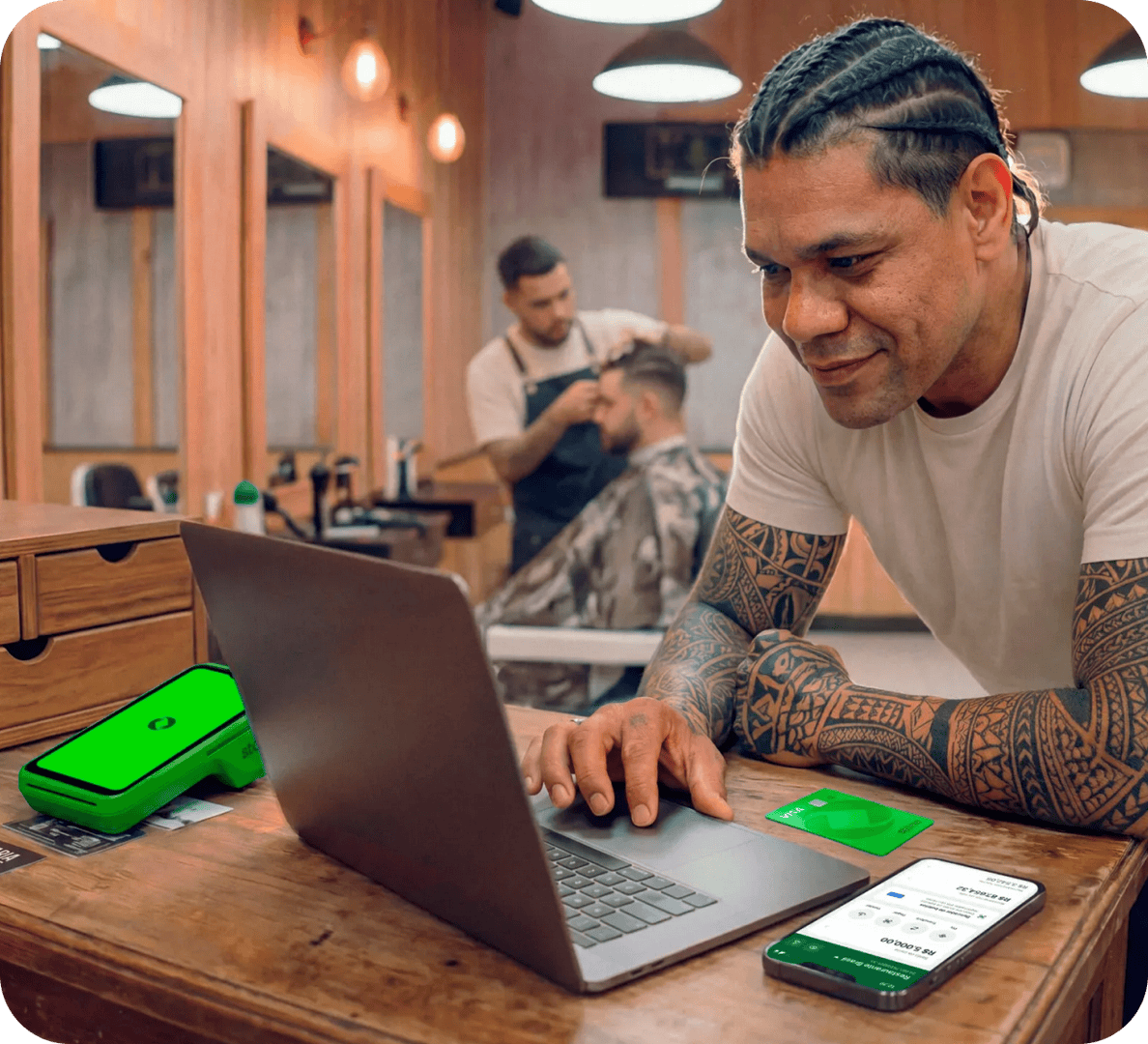 Funcionário em barbearia utilizando um computador junto com a maquininha stone