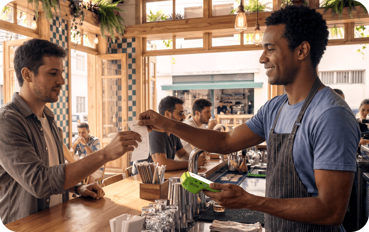 Garçom em bar entregando comprovante ao cliente em balcão