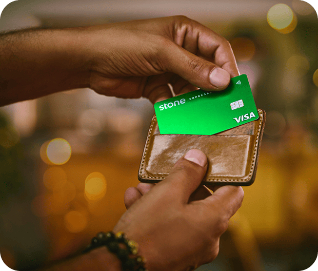 Empreendedora segurando o celular para utilizar o link de pagamento Stone em sua loja de roupas