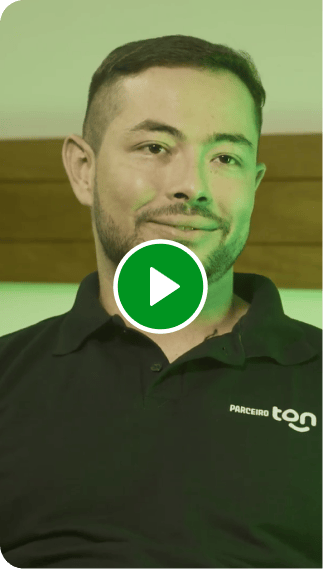 Consultor Renda Extra Ton. Homem com camisa preta sentado em uma poltrona verde.