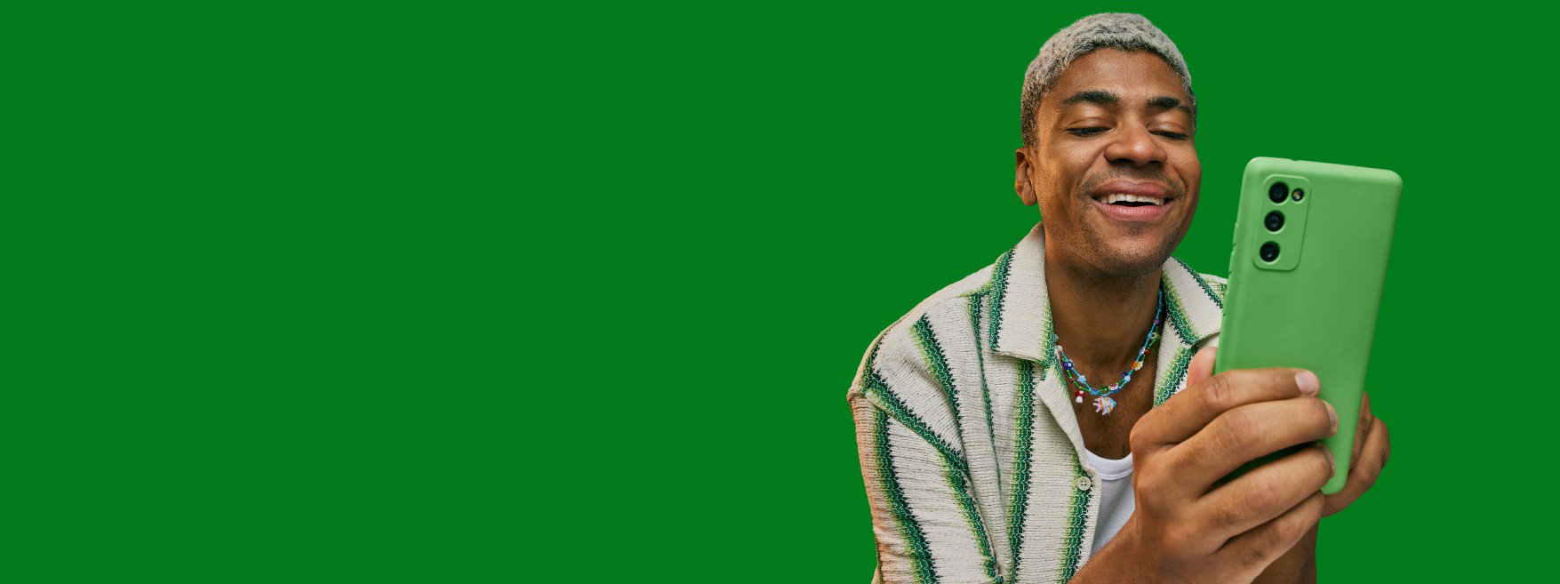 Homem observando a tela de seu celular verde