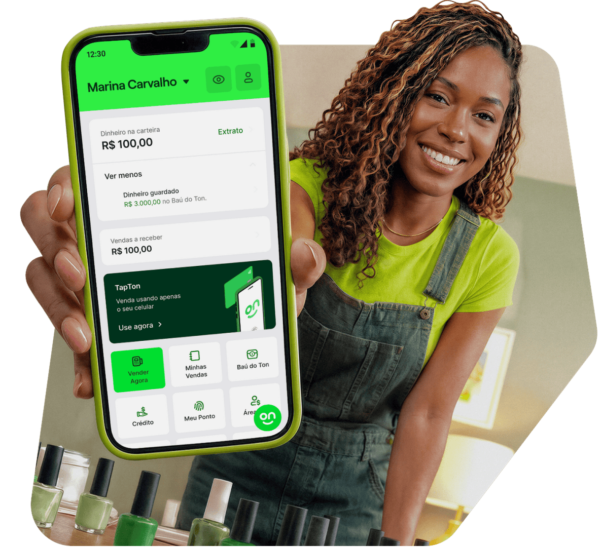 Empreendedora sorrindo, segurando o seu celular com o aplicativo com os serviços e o saldo de sua conta do Ton