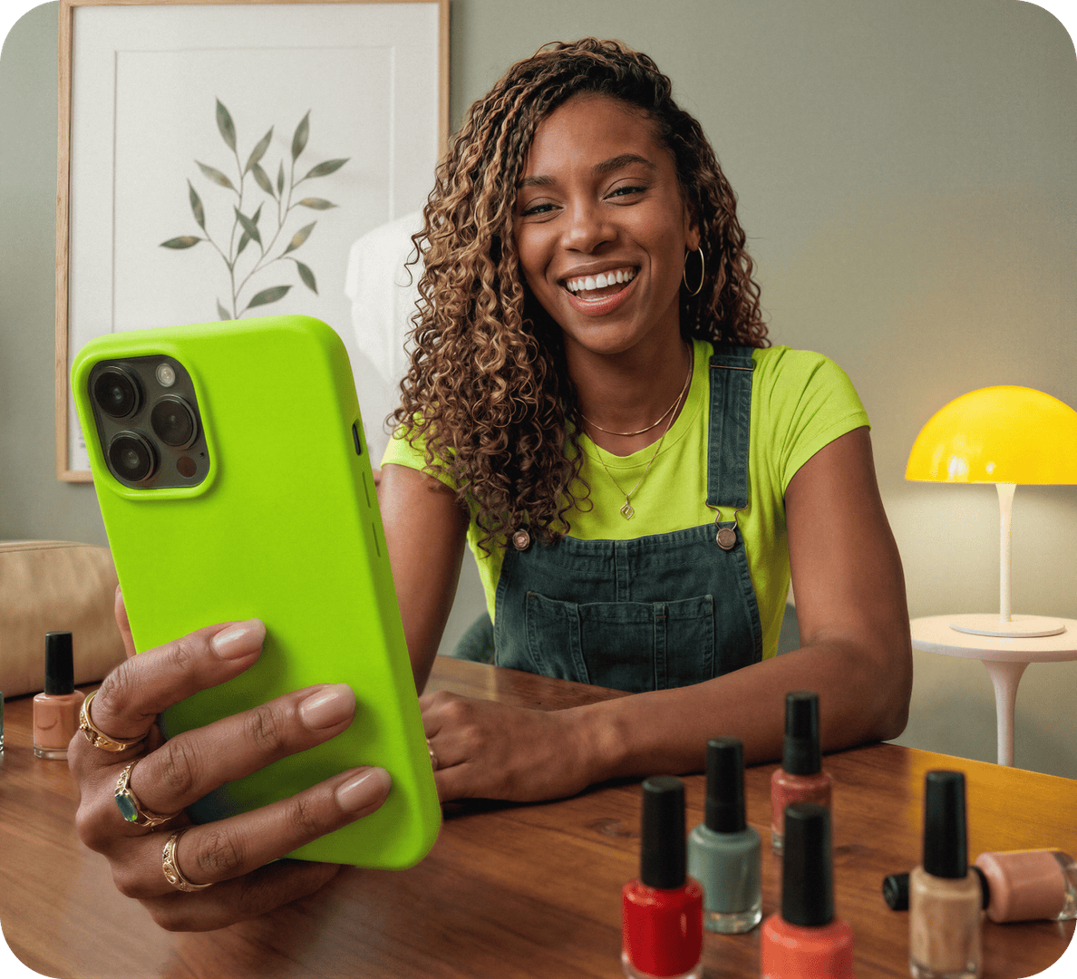 Empreendedora manicure sorrindo segurando o celular em seu salão